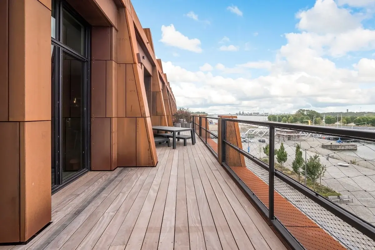 Modern appartementengebouw met roestkleurige stalen gevel aan een plein in Antwerpen